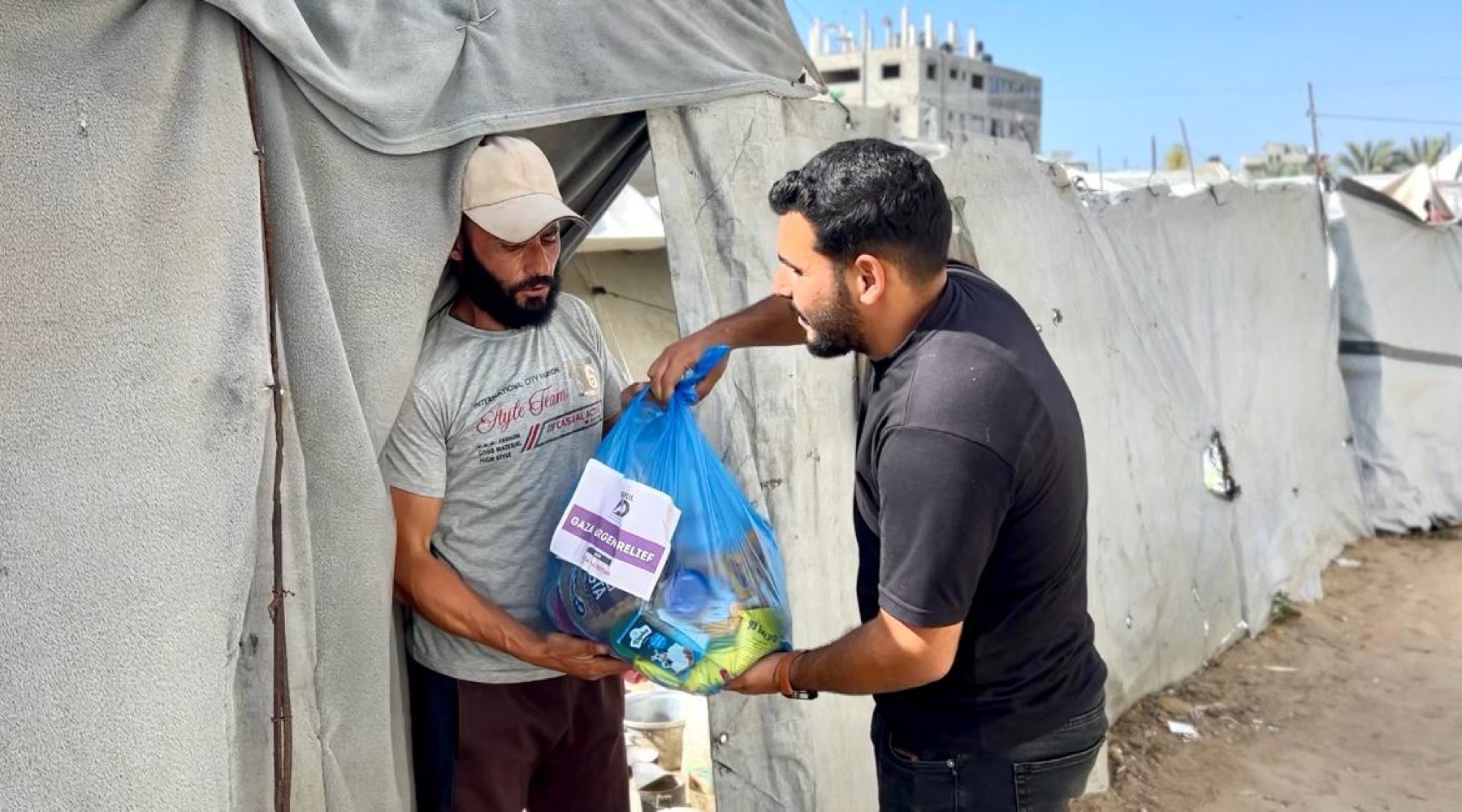 Ashraful Aid field team handing a food parcel to a Gaza resident