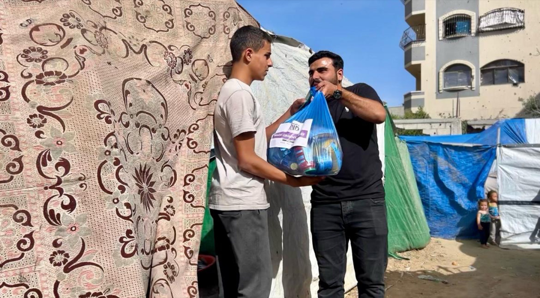 Ashraful Aid food parcel being received outside a temporary shelter